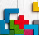 Top view on colorful wooden blocks folding on white wooden backg